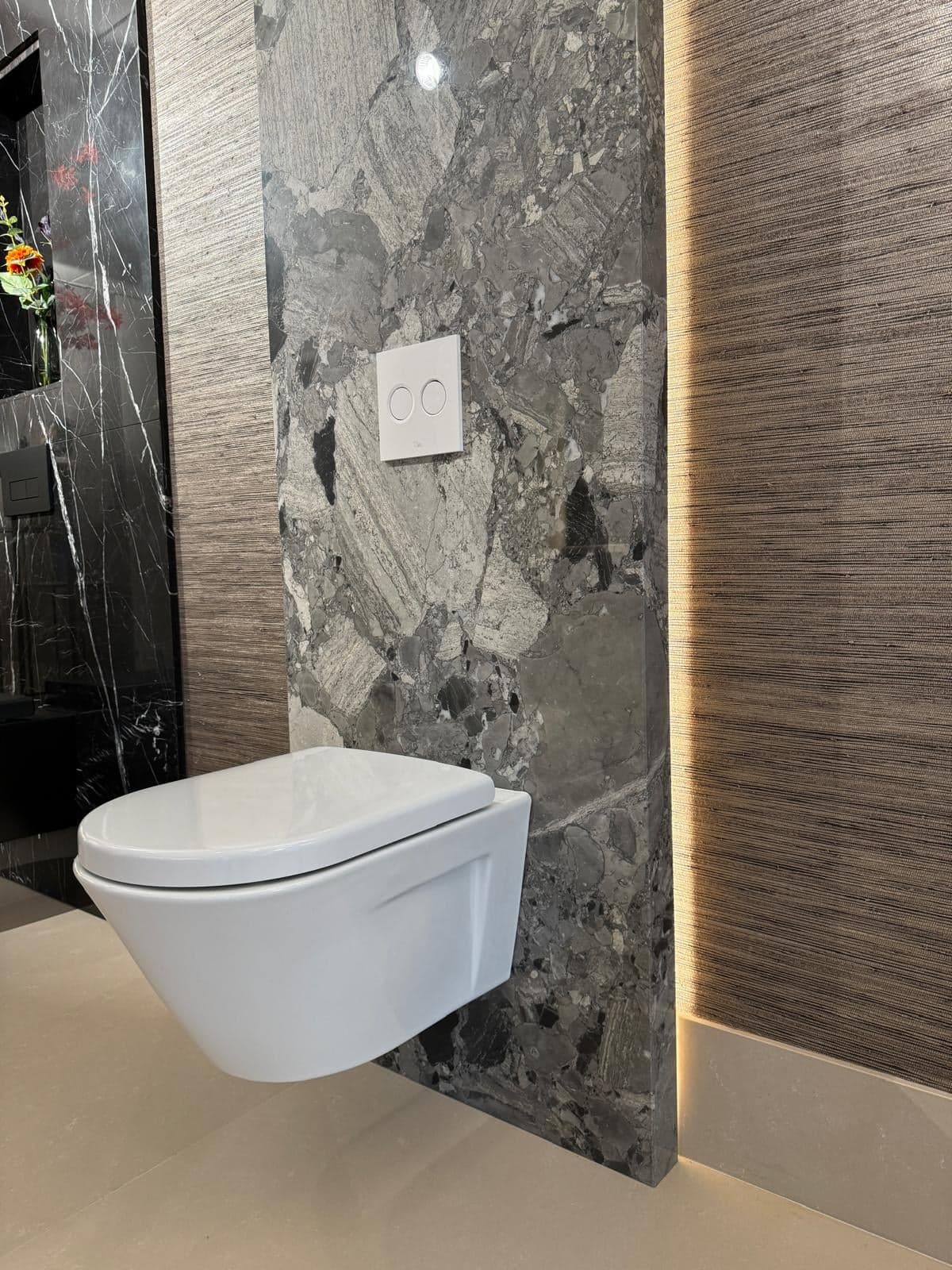Zwevend toilet bij een grijs marmeren wandpaneel in een natuursteen-showroom in Tilburg