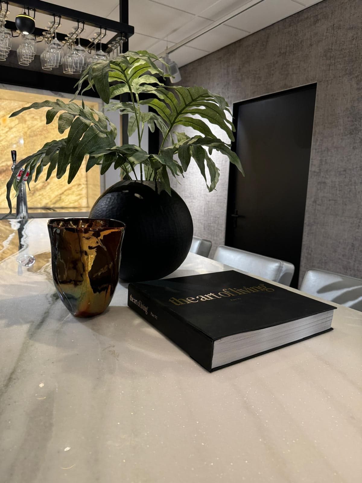 Stylingdetail met een zwarte vaas en een boek op wit natuursteen in een natuursteen-showroom in Tilburg