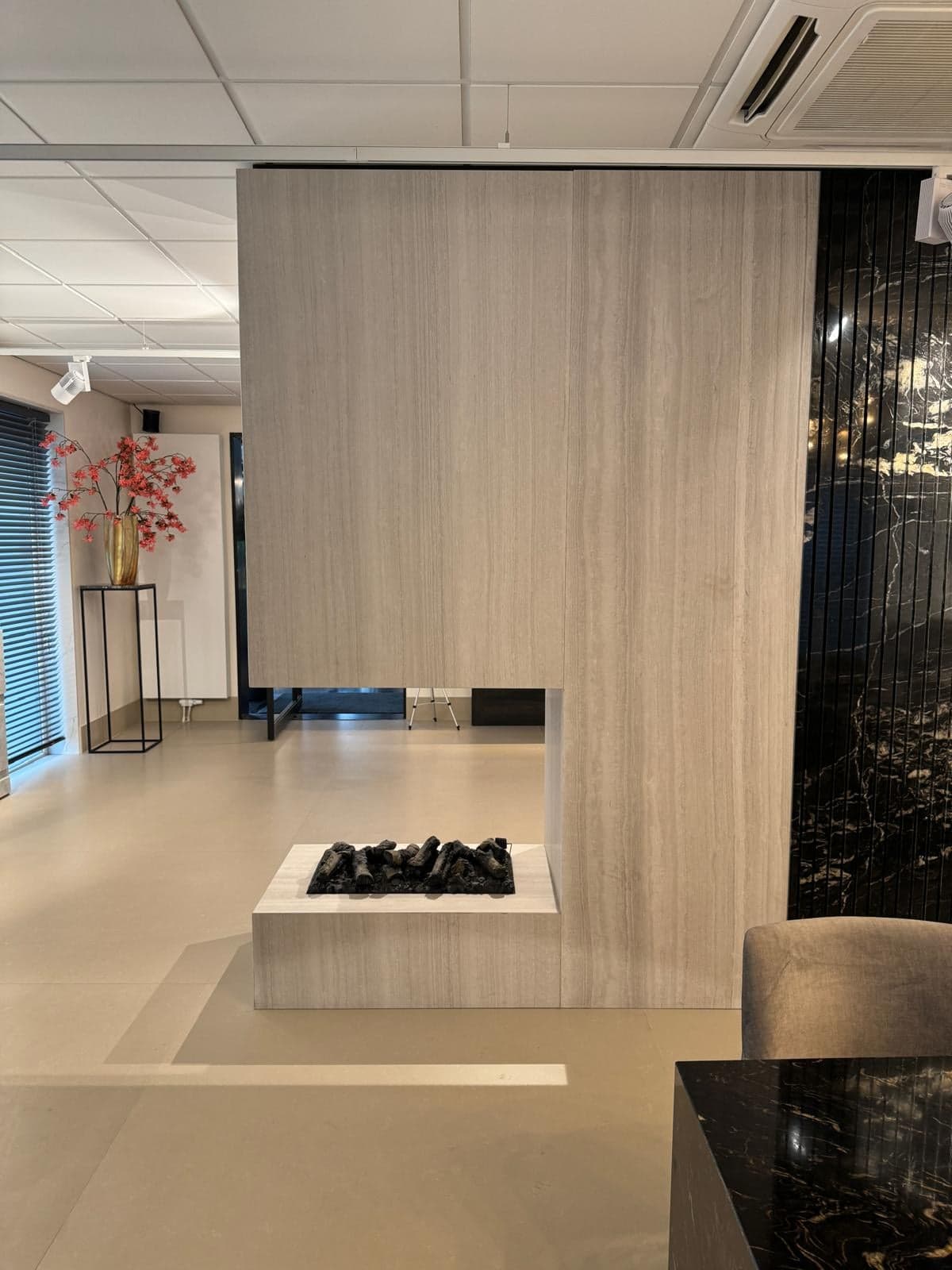 Lichte travertijnen scheidingswand in een natuursteen-showroom in Tilburg