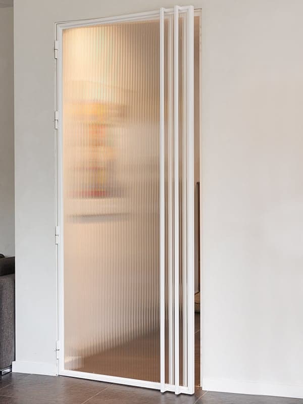 Ribbelglazen vouwwand als roomdivider in een woonhuis in Oisterwijk