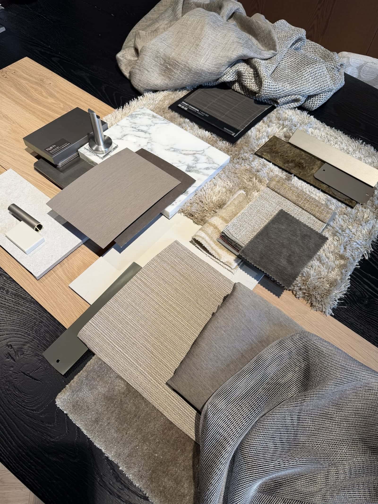 Moodboard met stalen van marmer, houtfineer, textiel en metaal op de ontwerptafel van Fullhouse Interieur in Schijndel